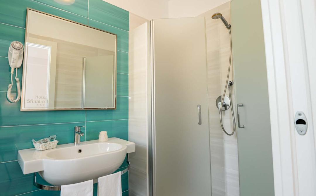 Modernes Badezimmer mit eleganter Dusche und beruhigenden türkisfarbenen Fliesen.