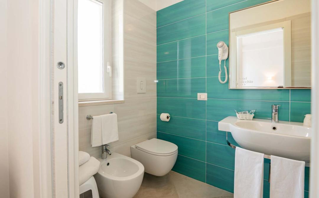 Helles, modernes Badezimmer mit grünen Fliesen und Föhn.